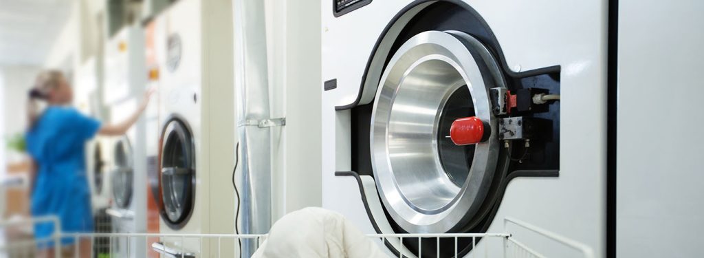 Waschmaschine und Angestellte im Hintergrund